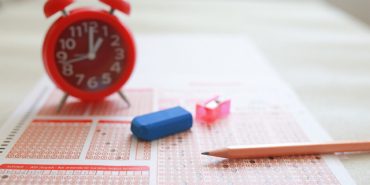 Answer sheet with pencil and alarm clock